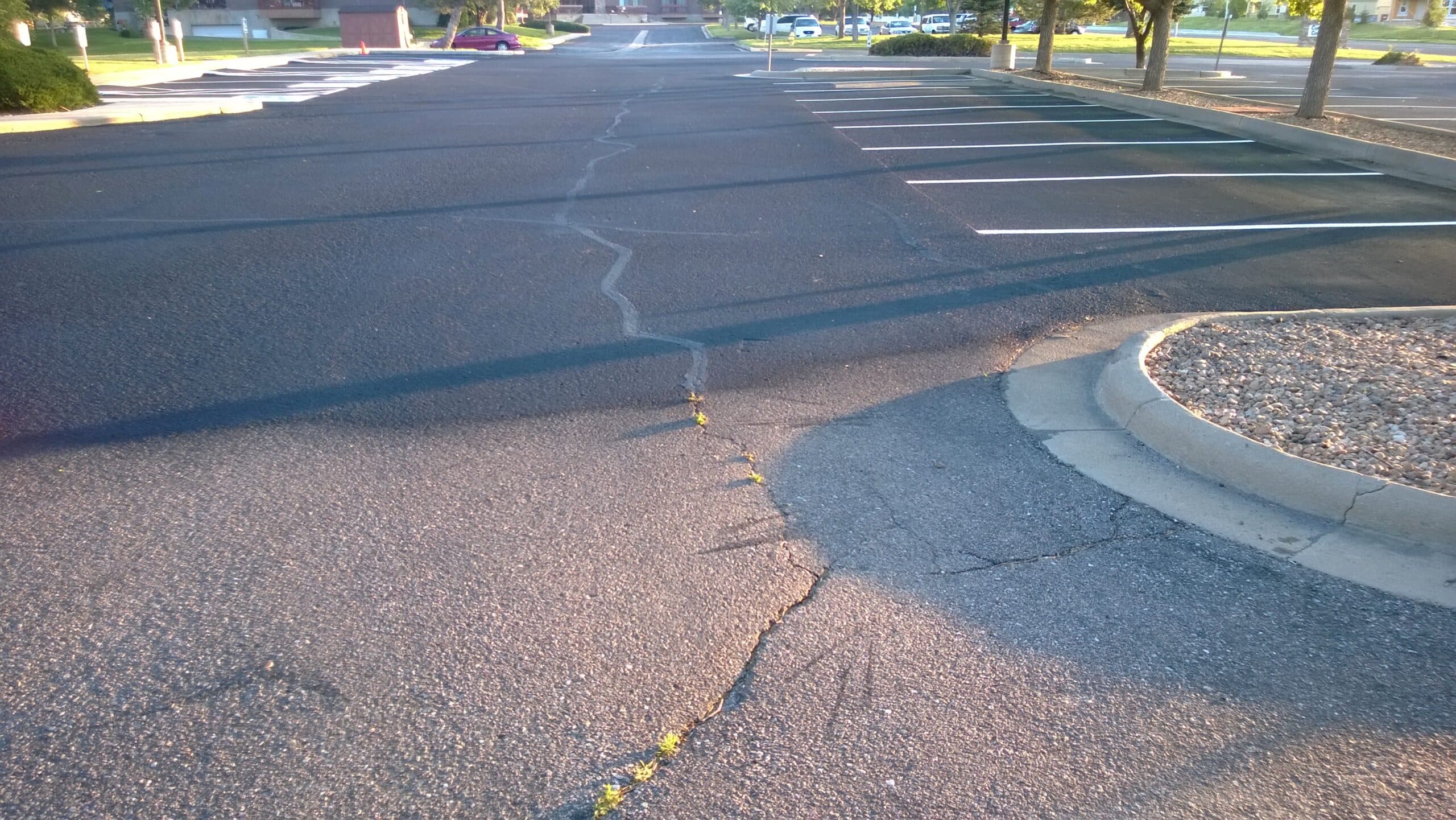 A parking lot half sealcoated, before and after